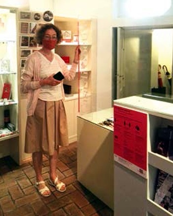   Die wissenschaftliche Mitar­beiterin Claudia Nordhoff mit Maske vor der Plexiglasscheibe im Eingangsbereich des Museums, Foto: Maria Gazzetti