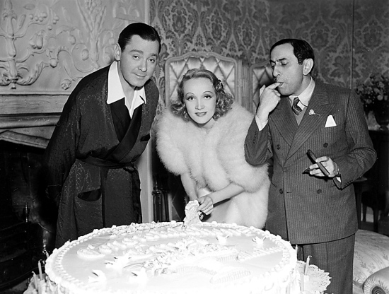 Tortenanschnitt mit Herbert Marshall (li.) und Ernst Lubitsch am Set von ‘Angel‘, Hollywood 1937, © Foto: Filmmuseum Berlin - Marlene-Dietrich-Collection